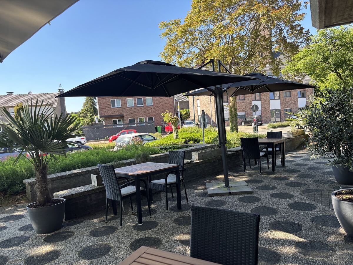 Terrasse der Pizzeria Rialto mit Sonnenschirmen